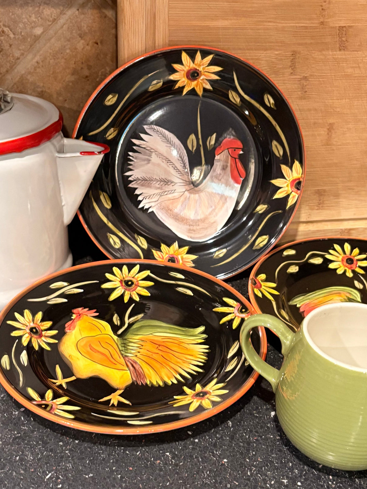 Vintage black hand-painted rooster and sunflower ceramic plates with green mug and white enamelware